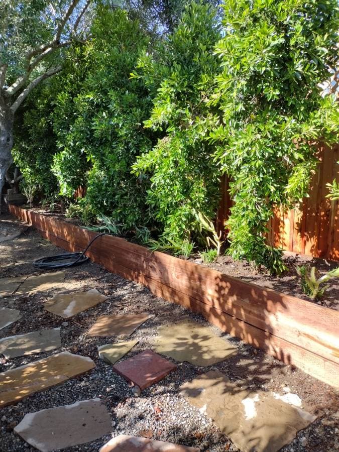 Wood retaining wall and drainage work for outdoor property improvement