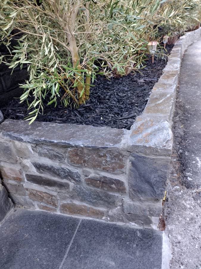 Raised stone planter wall built for landscaping and soil retention