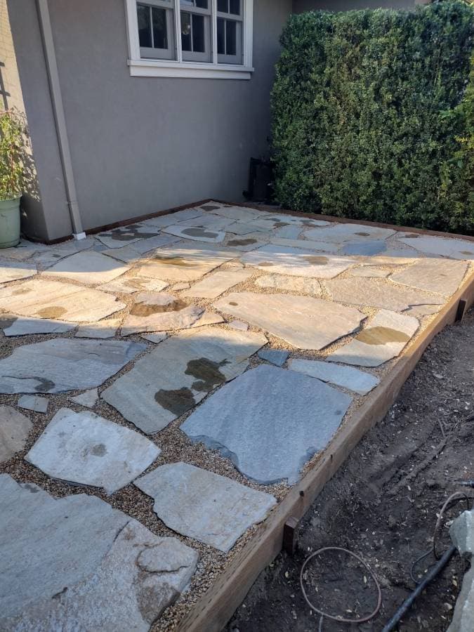 Flagstone patio installation with natural stone layout